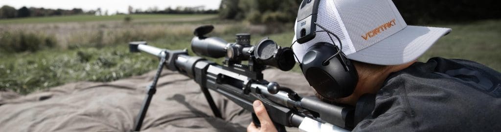 Chad laying on the ground shooting a 50 caliber barrerl with a Vortakt hat on